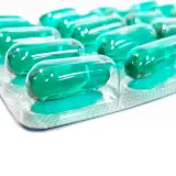 Blister opakowania z zielonymi kapsułkami, które mogą być lekiem **Inflanor Max**.