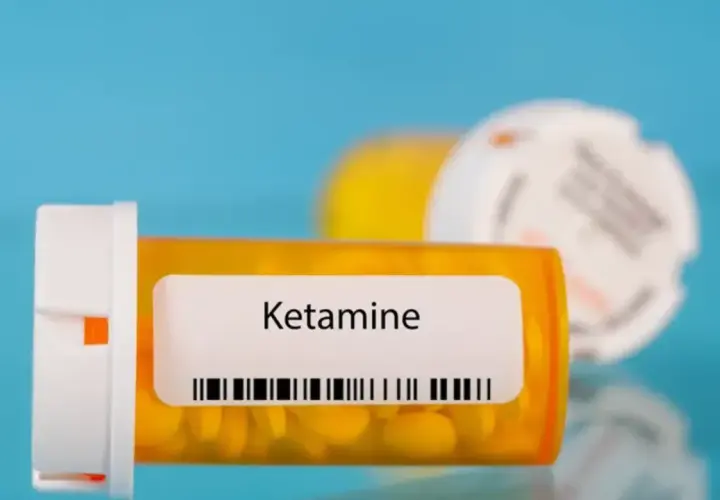 Lek ketamina co to? Pomarańczowa buteleczka z tabletkami i etykietą "Ketamine".