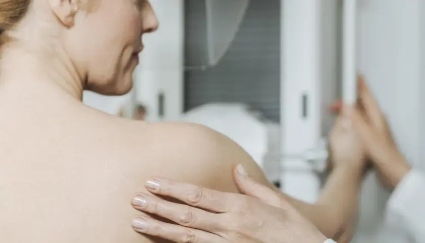Kobieta podczas mammografii. Badanie to jest kluczowe w diagnostyce raka piersi, a leczenie często obejmuje tamoxifen.